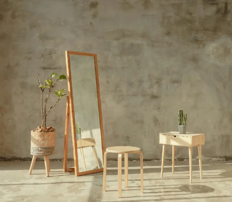 A mirror and stool in front of a wall.