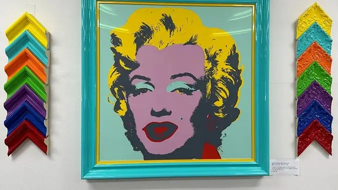 A painting of marilyn monroe in a blue frame.