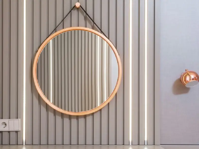 A round mirror hanging on the wall above a door.
