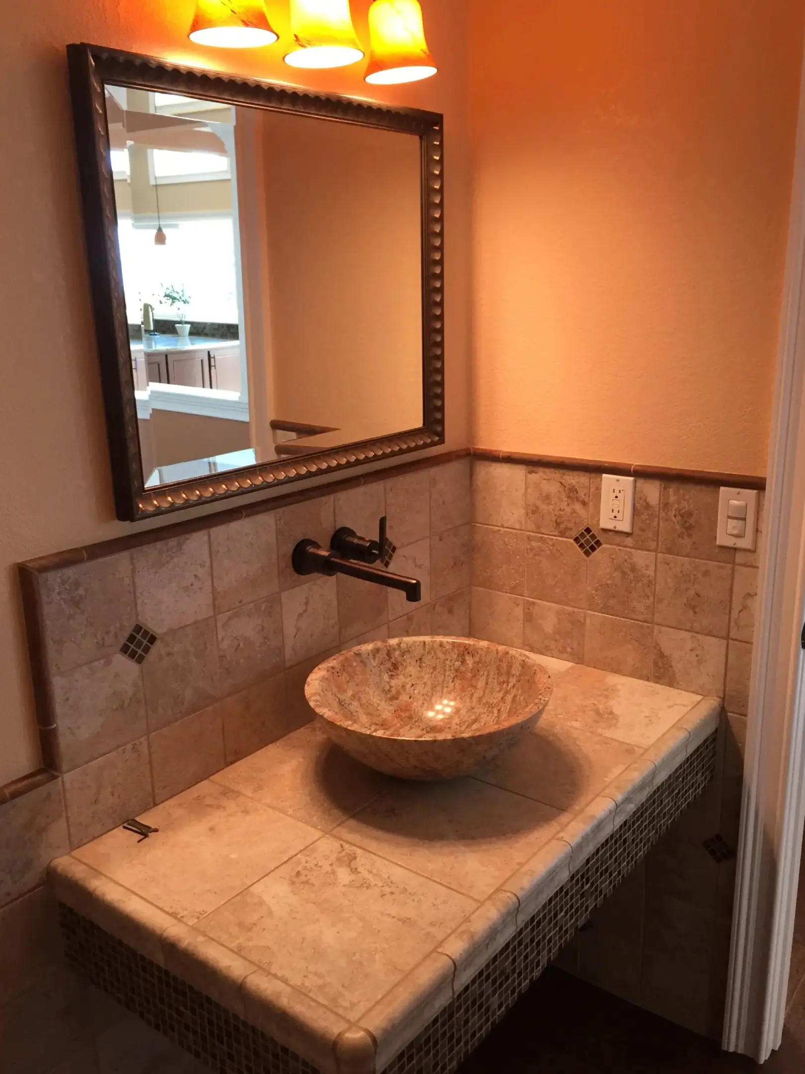 A bathroom with marble counter top and sink.