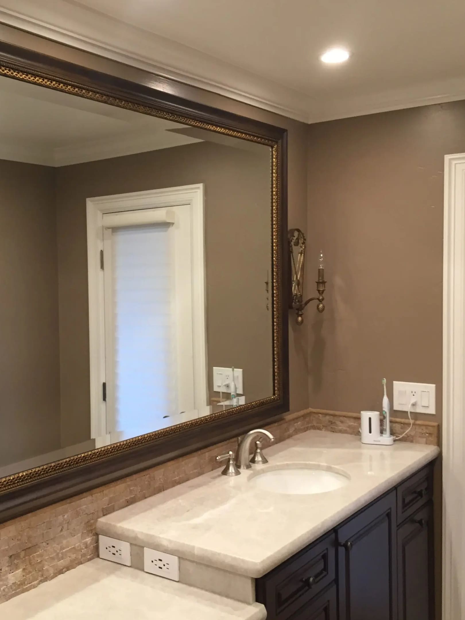 A bathroom with a large mirror and sink.