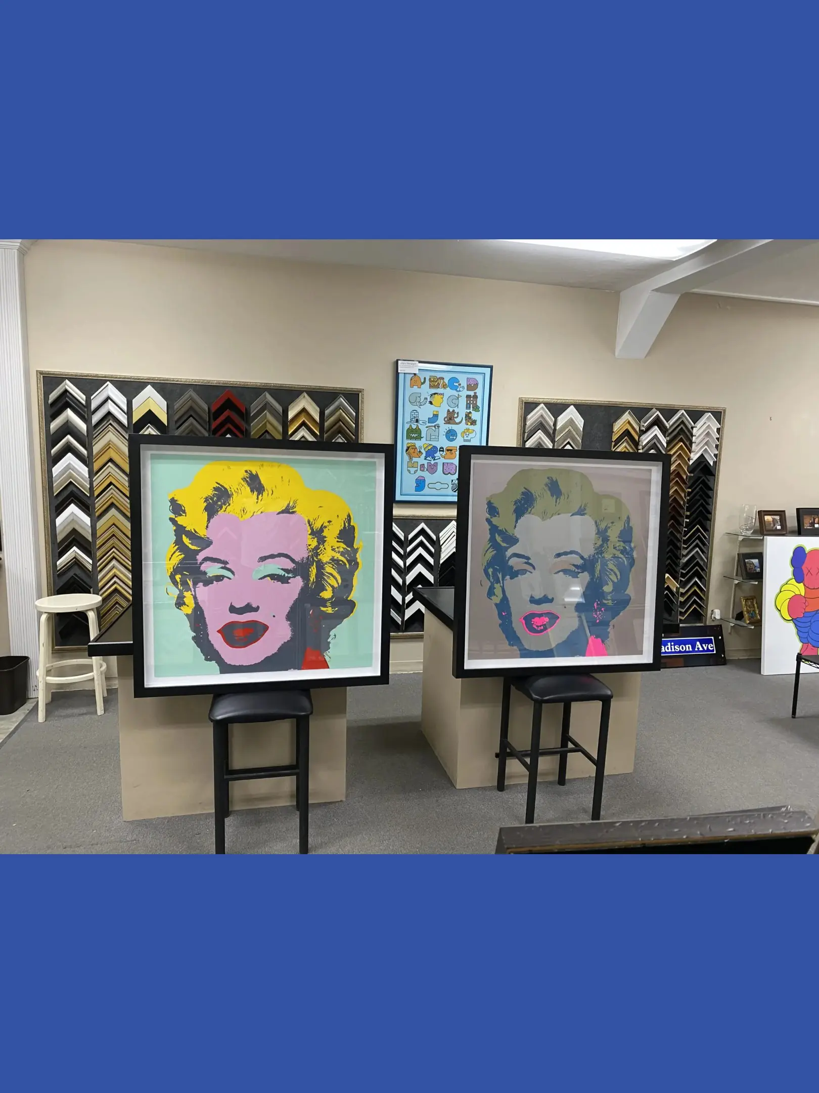 Two paintings of marilyn monroe are displayed in a room.