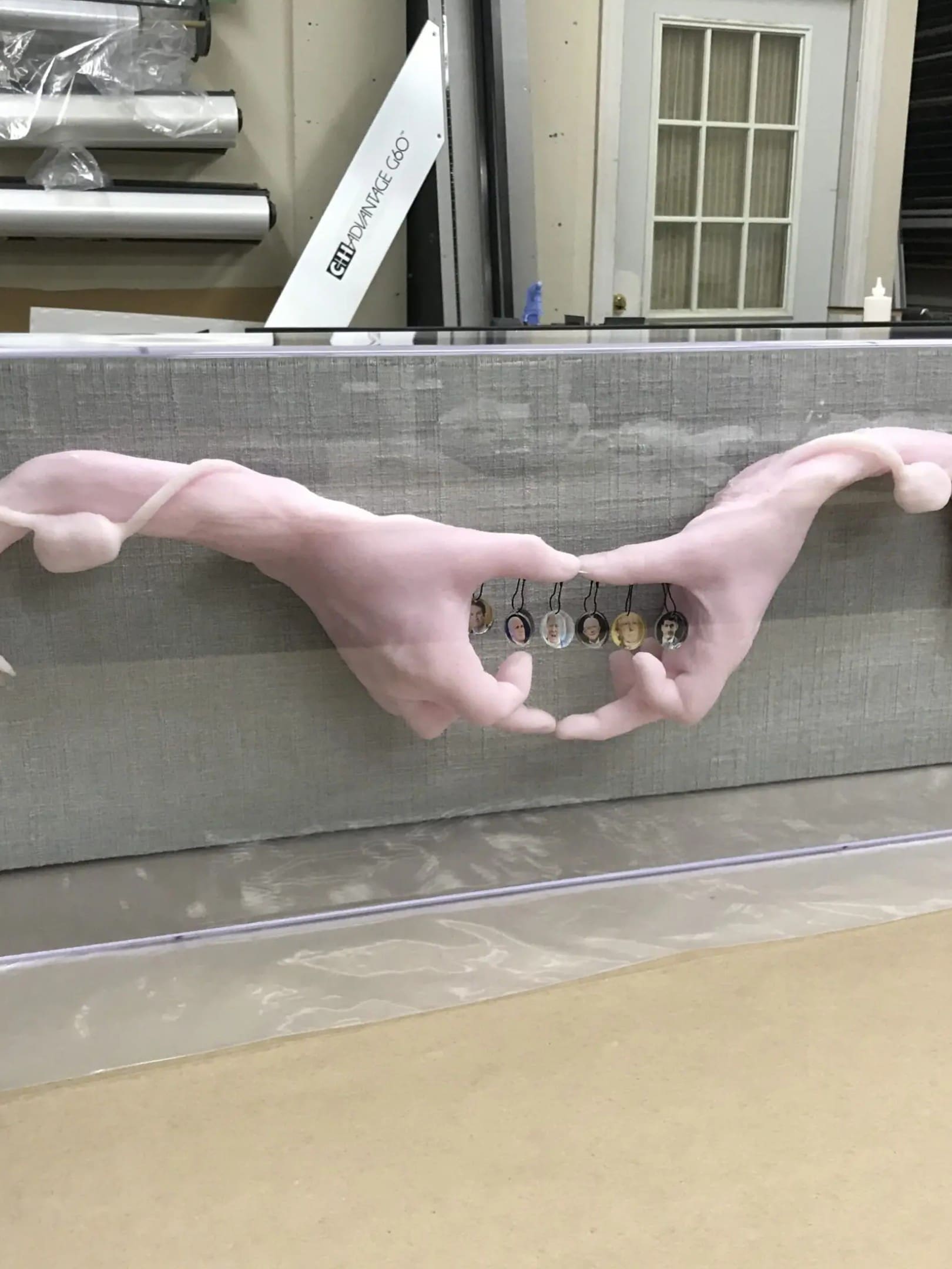 A pink hand is holding onto the side of a wall.