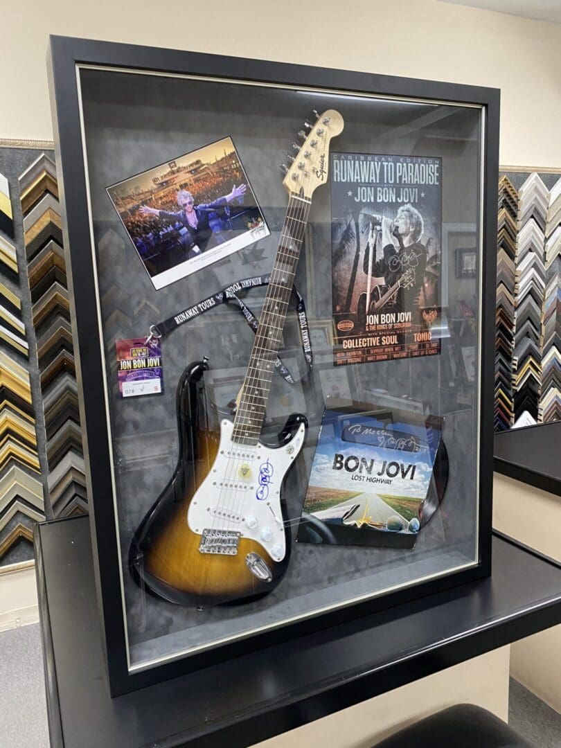 A guitar case with some books and a guitar