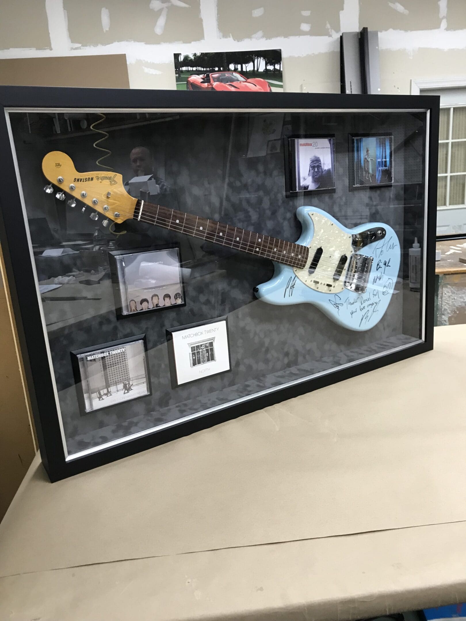 A guitar that is in a shadow box.