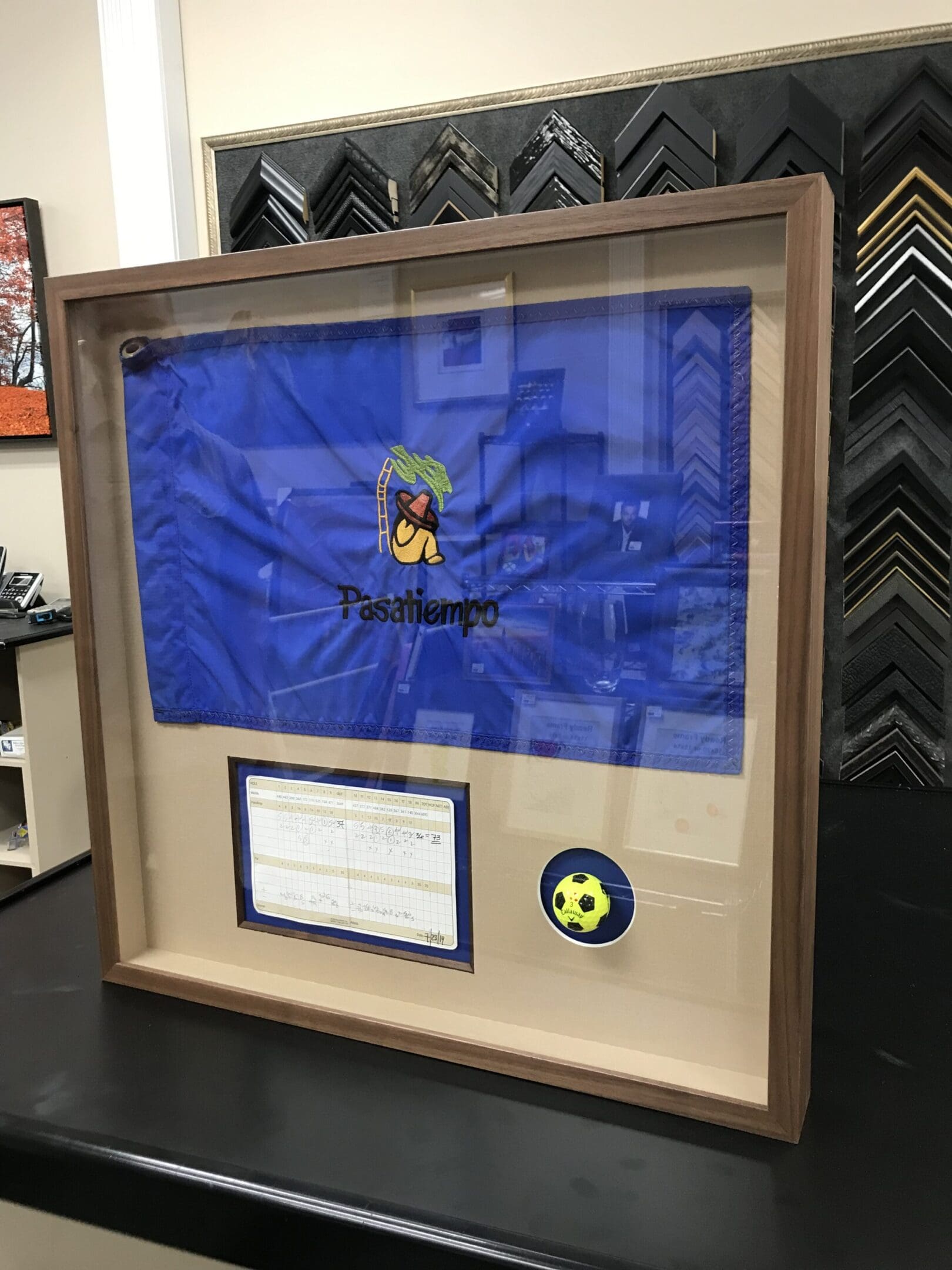 A framed flag with a soccer ball in it.
