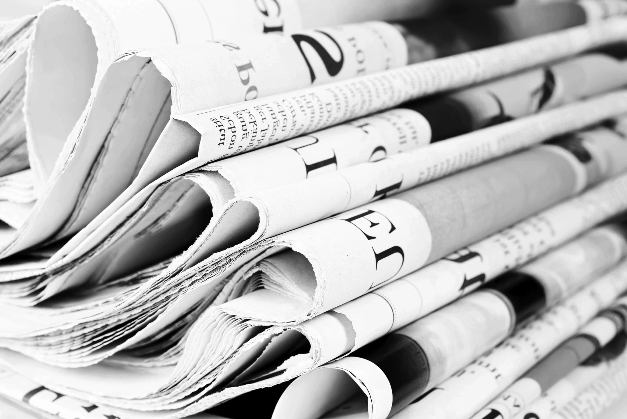 A stack of newspapers in black and white.
